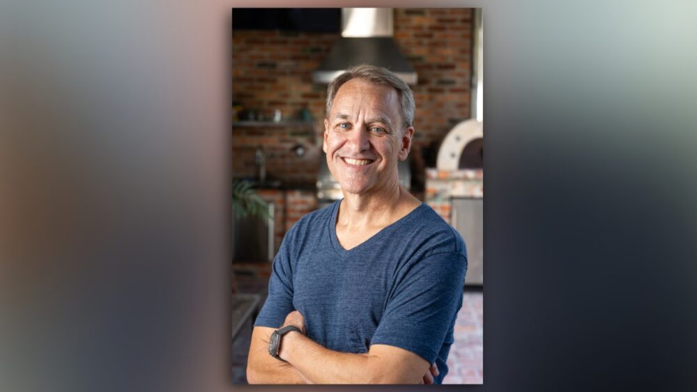 Nelson Castellano at home Nelson Castellano standing in a brick kitchen with arms crossed.