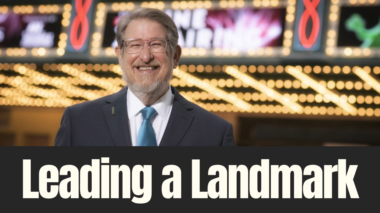 John Bell smiles outside Tampa Theatre beneath the historic marquee lights during an interview about his leadership and legacy.