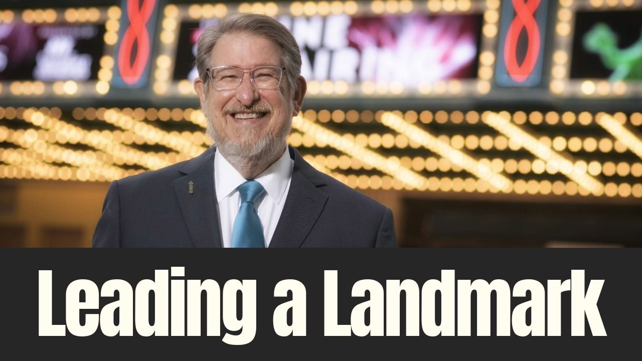 John Bell smiles outside Tampa Theatre beneath the historic marquee lights during an interview about his leadership and legacy.