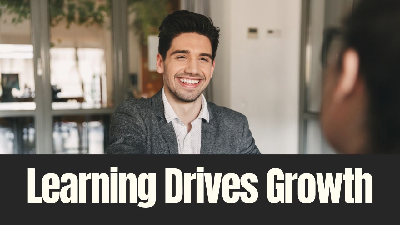 A professional meeting scene shows a smiling young man in a blazer speaking with a colleague across a table, with the words “Learning Drives Growth” overlaid at the bottom.