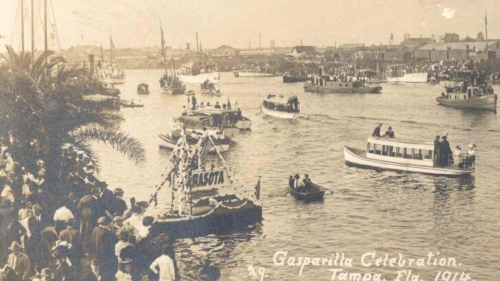 Historic boats crowd the Hillsborough River during Tampa’s 1914 Gasparilla Celebration as spectators line the waterfront.
