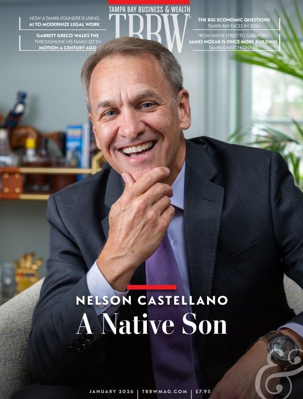 Nelson Castellano, managing shareholder at Trenam, seated in his Tampa office, smiling in a suit and tie