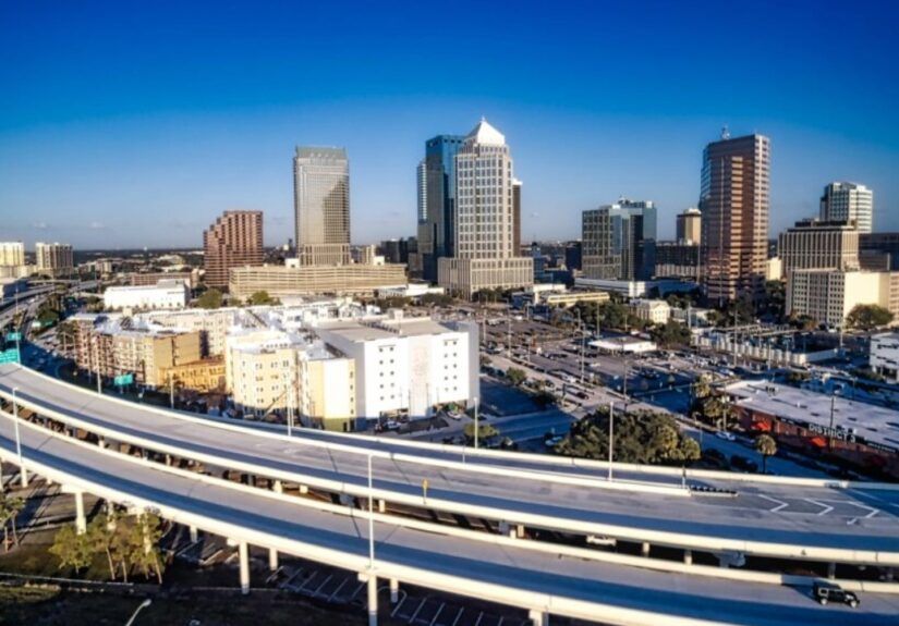 Aerial view of the Lee Roy Selmon Expressway curving toward downtown Tampa with skyline in background.