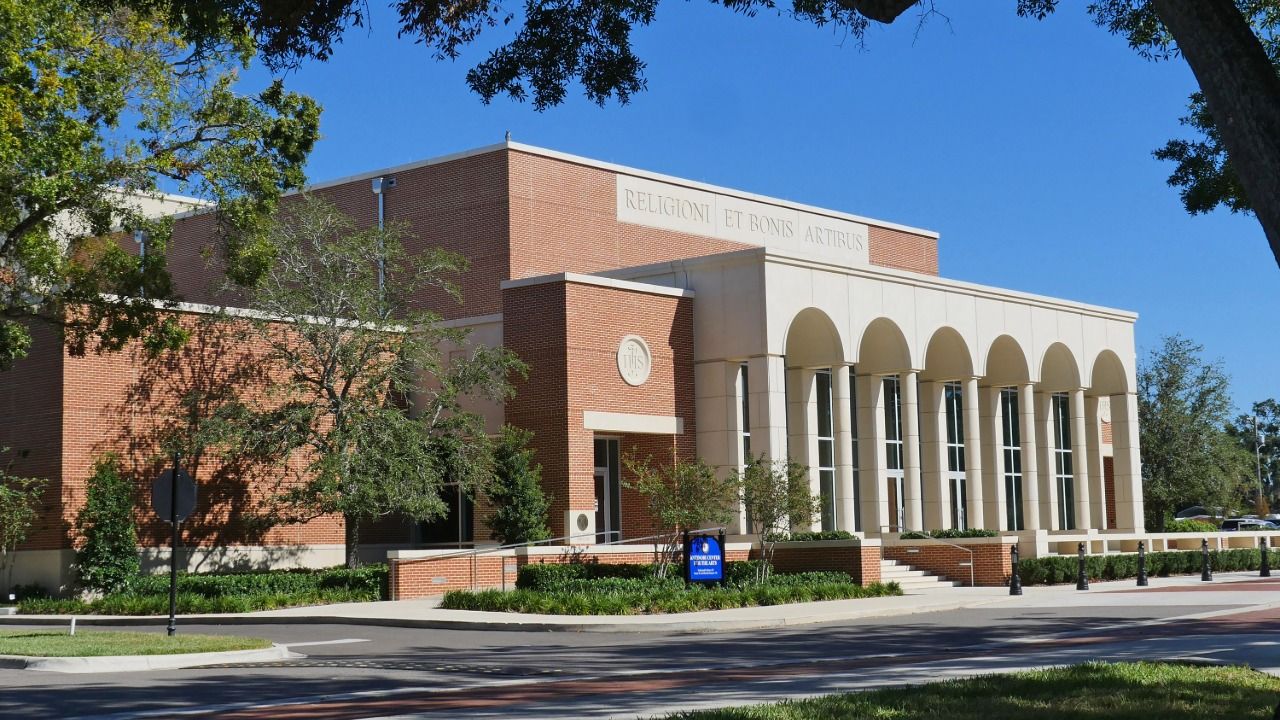 esuit High School campus building in Tampa with brick exterior and arched colonnade.