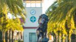Lion statue on the Saint Leo University campus with the university’s clock tower in the background