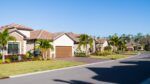 Suburban Florida homes with tile roofs and palm trees in a residential neighborhood