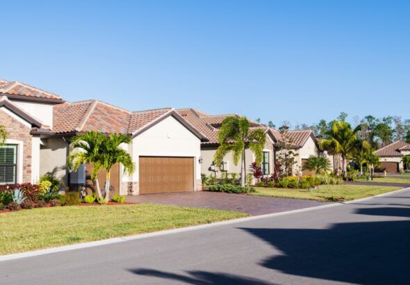 Suburban Florida homes with tile roofs and palm trees in a residential neighborhood