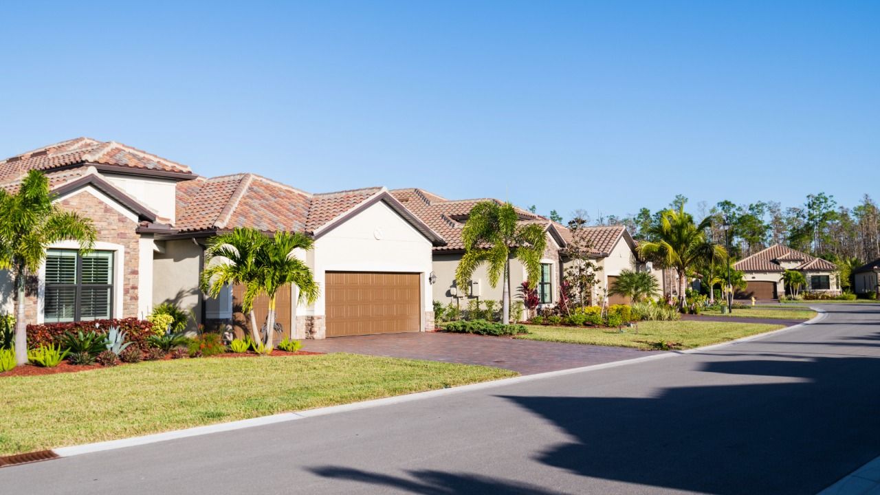 Suburban Florida homes with tile roofs and palm trees in a residential neighborhood