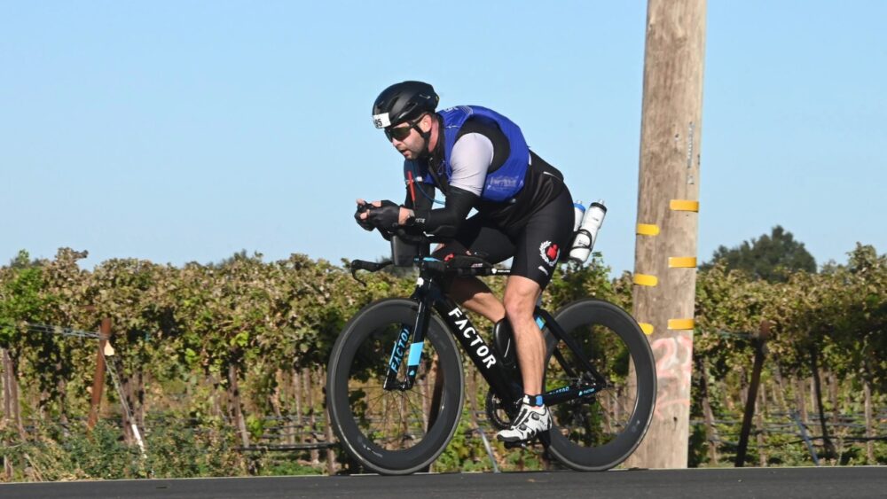 Chris McVety competes in the cycling portion of an Ironman race in full racing gear