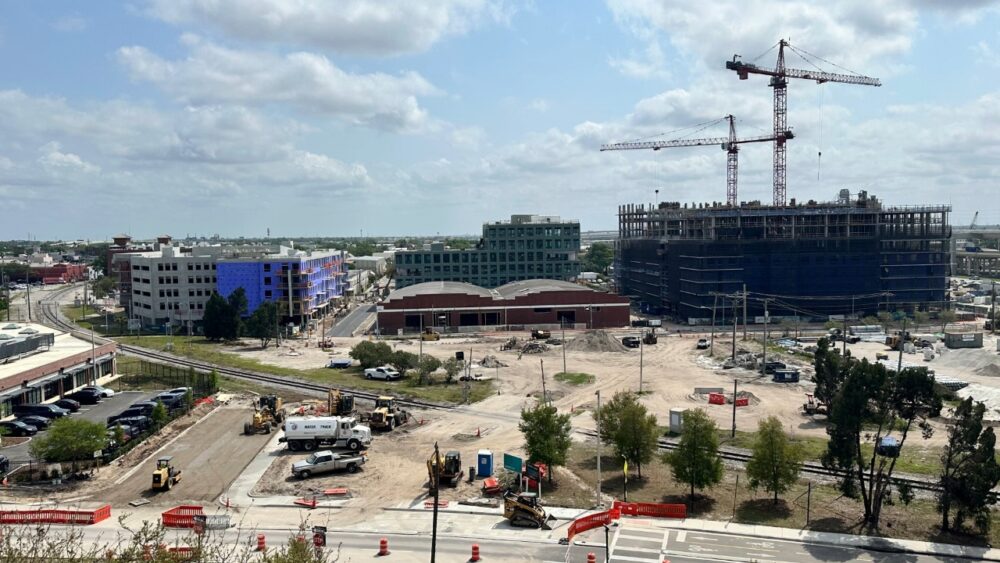 Aerial view of the Gasworx redevelopment in Ybor City showing construction sites, cranes, new mid-rise buildings and surrounding rail lines.