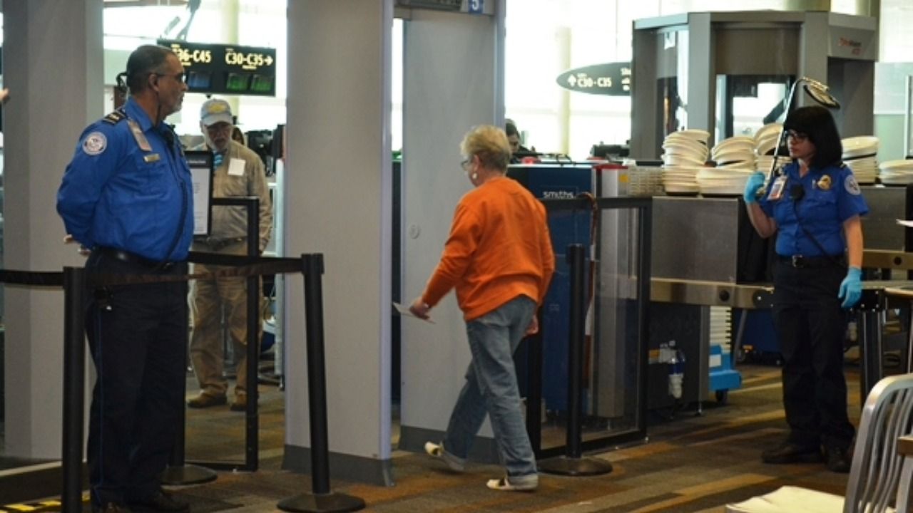 TSA officers screen passengers at airport security checkpoint during federal shutdown