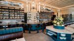 Interior of Boulon restaurant featuring bar seating, marble surfaces and illuminated shelving in downtown Tampa