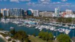 Aerial view of downtown Sarasota waterfront with marina, boats and surrounding high-rise buildings