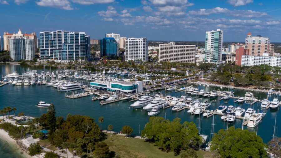 Aerial view of downtown Sarasota waterfront with marina, boats and surrounding high-rise buildings