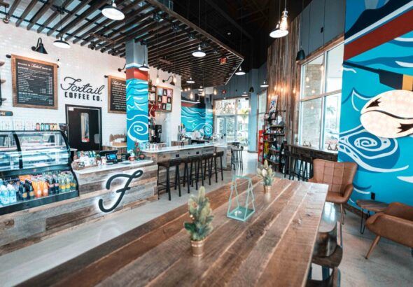 Interior of Foxtail Coffee Sarasota cafe with seating, espresso bar and mural artwork