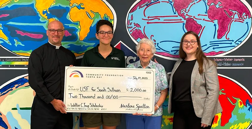 Student receives scholarship check from Community Foundation Tampa Bay with family and presenters