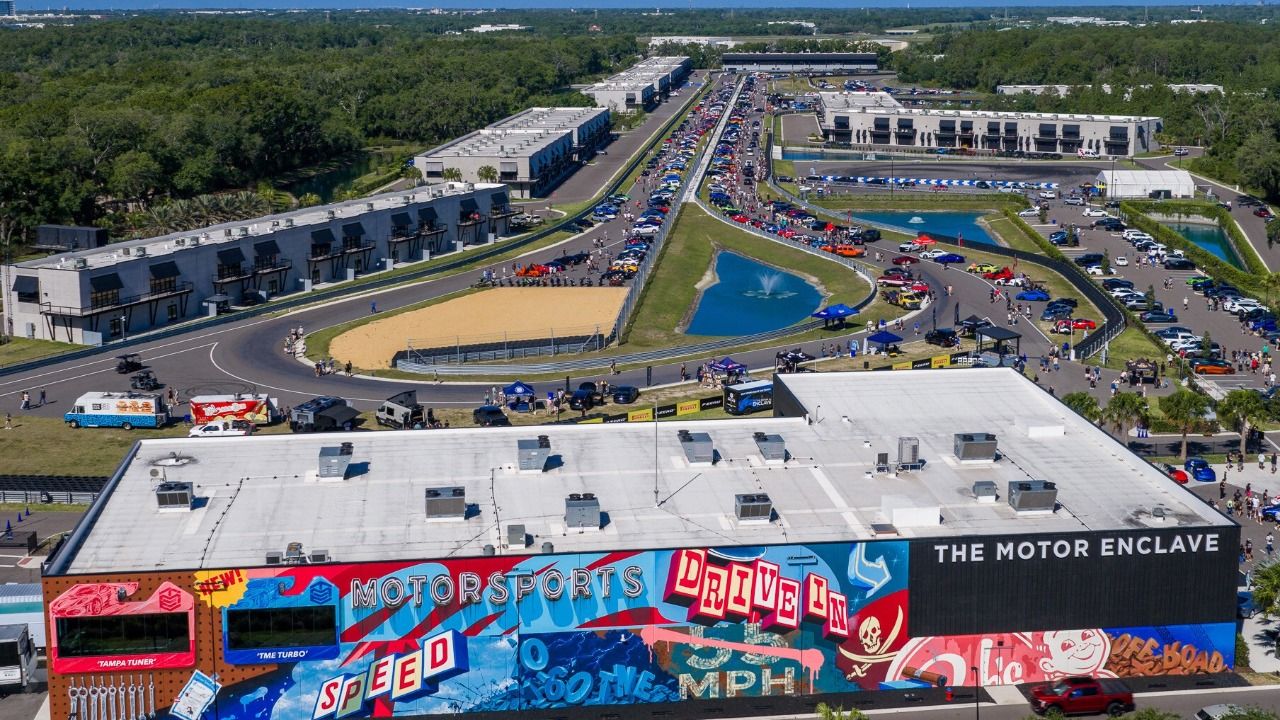 Aerial view of The Motor Enclave in Tampa with racetrack, garages, and event crowds