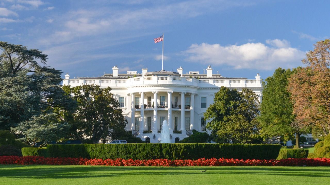 The White House in Washington, D.C., with U.S. flag and landscaped grounds