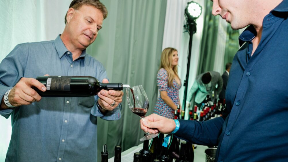 Man pours red wine for guest during Bern’s Winefest tasting in Tampa