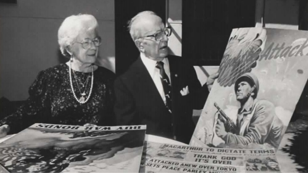 Historic photo of Emiliano Salcines reviewing World War II posters in West Tampa
