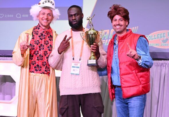 Nick Friedman, Modi Oyewole and Omar Soliman hold a trophy onstage at a College HUNKS event