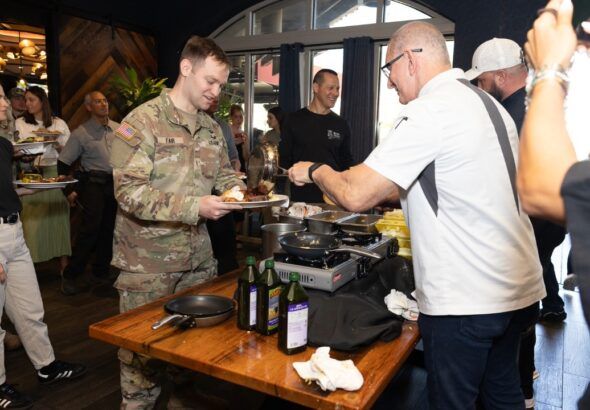 Chef Robert Irvine serves a meal to a U.S. service member during a Tampa Bay Wine & Food Festival event.
