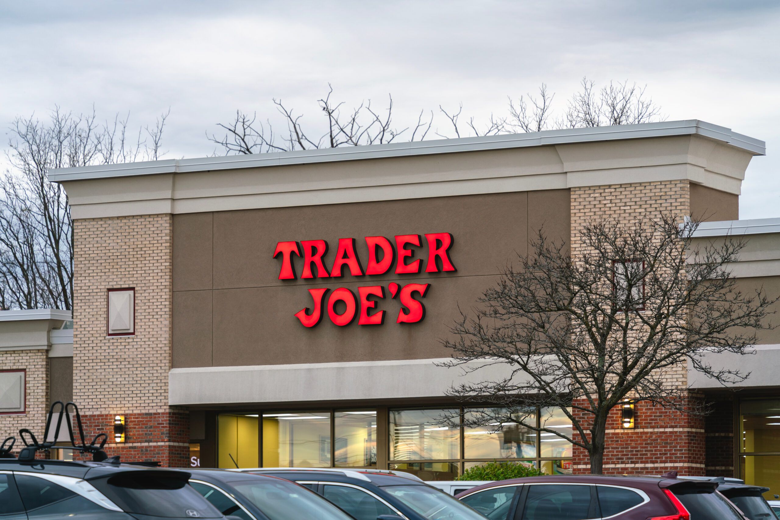 Exterior of a Trader Joe’s grocery store with illuminated signage above the entrance.