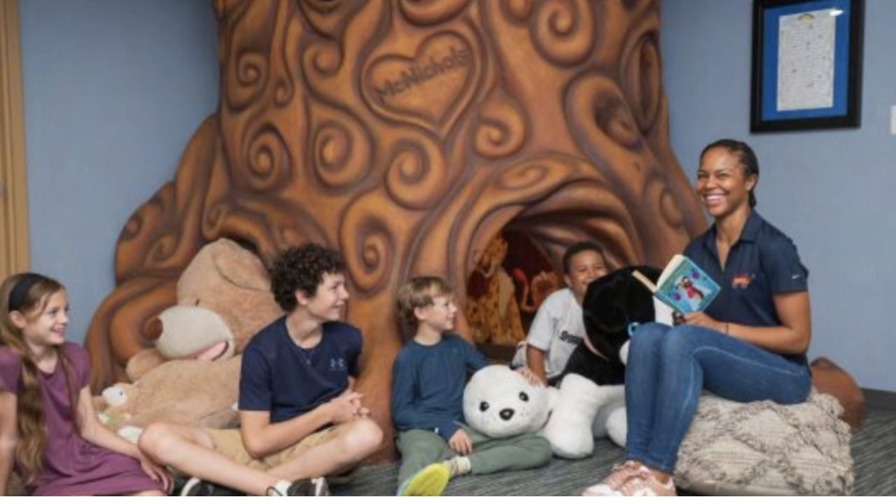 Children and a staff member gather for story time inside a reading space at A Kid's Place of Tampa Bay.