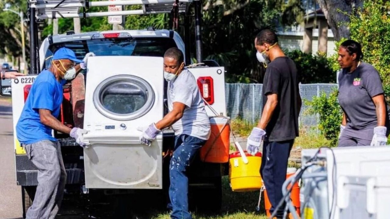 Workers with St. Petersburg's Hometown Haulers program load storm-damaged appliances onto a truck after Hurricanes Helene and Milton.