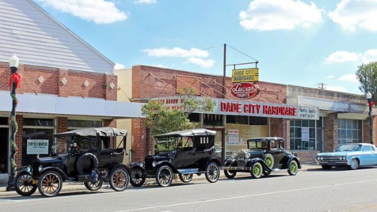 Historic storefronts line downtown Dade City, including Dade City Hardware and several vintage automobiles.
