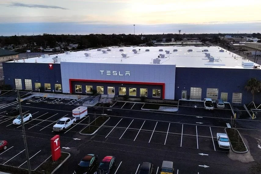 Tesla's sales and service center in Lealman, Florida, with a large showroom and service building viewed from above.