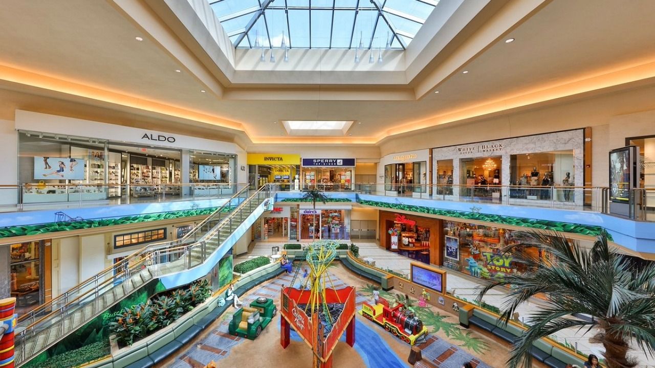Interior view of International Plaza in Tampa, showing the multi-level shopping center with retailers, skylights and the central children's play area.