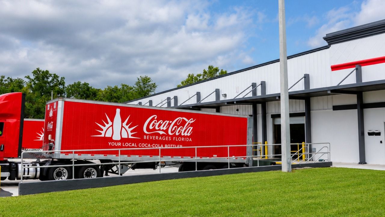 Coca-Cola Beverages Florida truck parked at a distribution center loading dock.