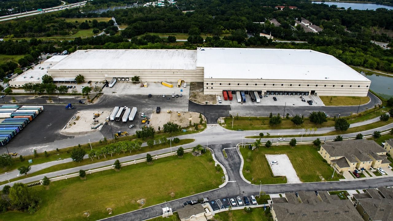 Aerial view of the Ashley Furniture warehouse and distribution center in Brandon, with loading docks and trailers.