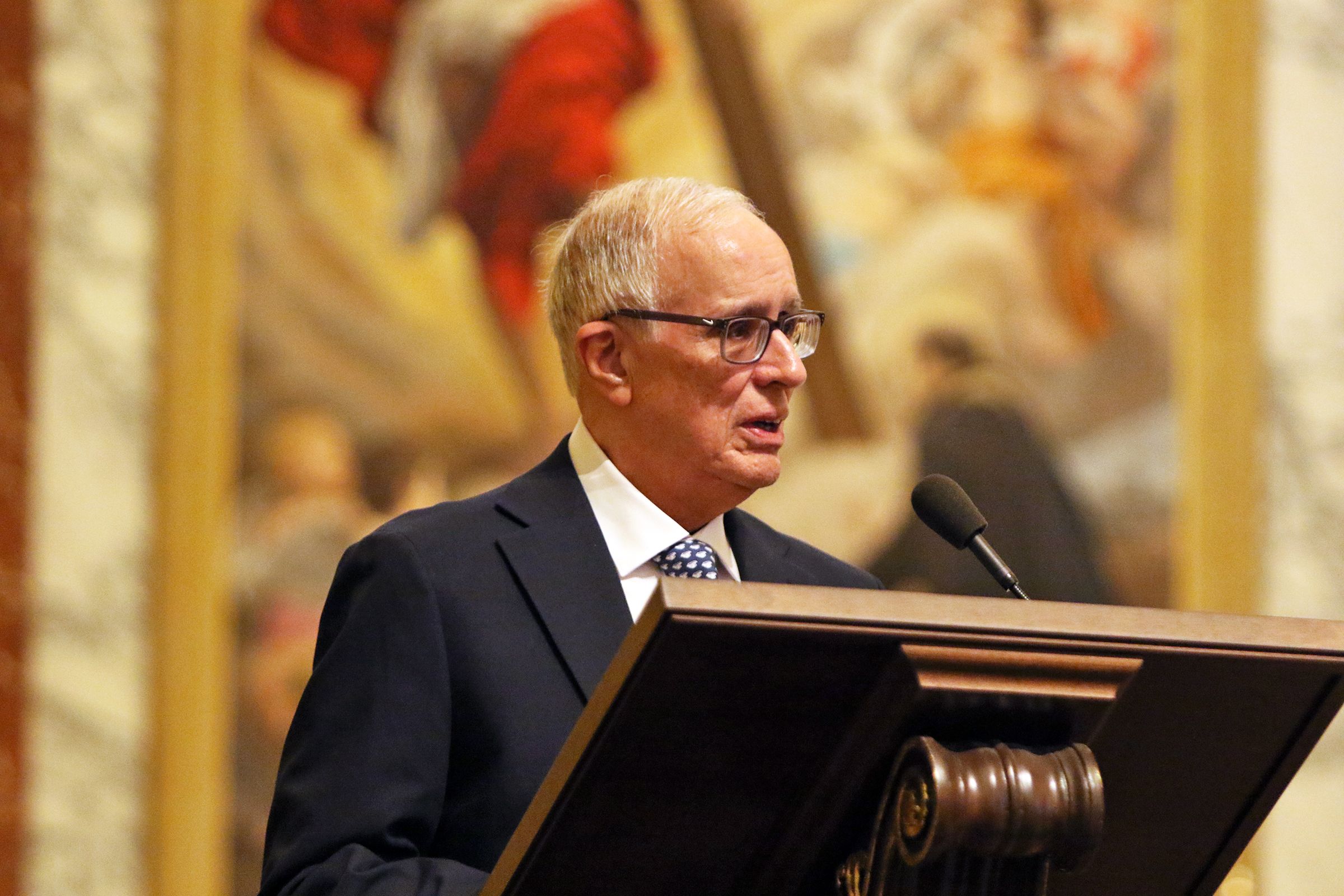 Dr. Manuel Mon speaks at a lectern during Convocation at Jesuit High School in Tampa.