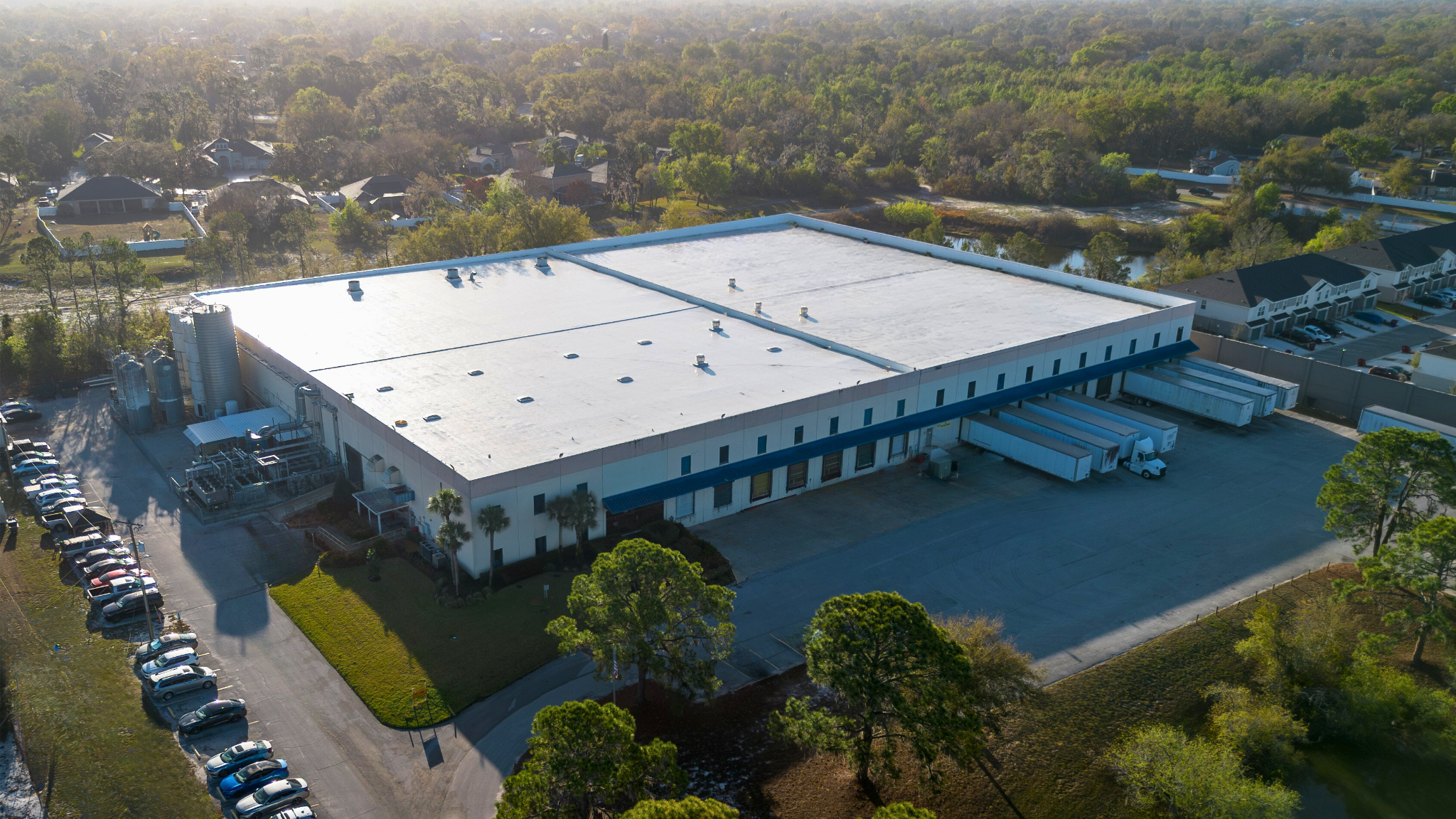 Aerial view of the LidWorks manufacturing facility in Plant City with loading docks and tractor-trailers.