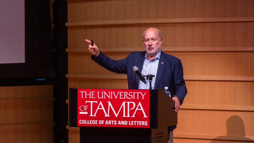 Former NOAA Administrator Rick Spinrad speaks at a podium at the University of Tampa.