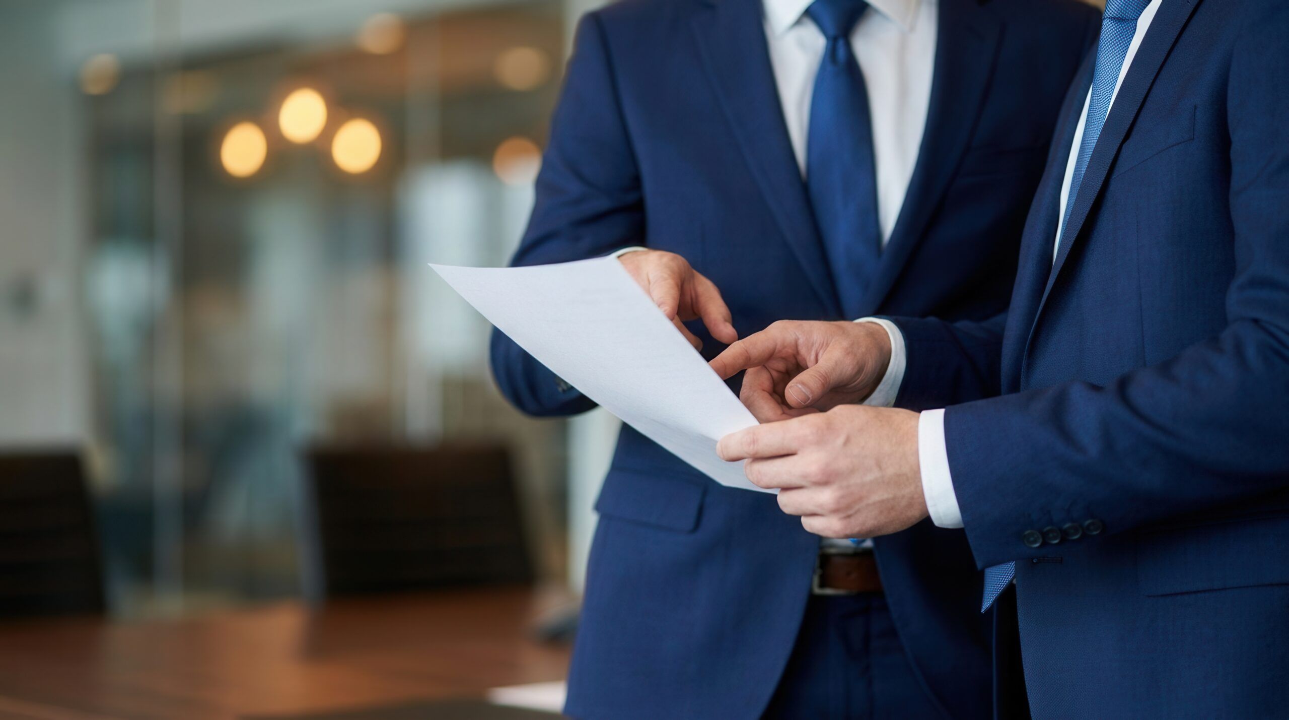 Two financial professionals review a document in an office