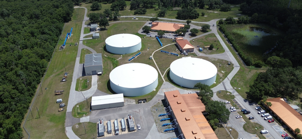 Aerial view of three large white water storage tanks and surrounding facilities at Cypress Creek.
