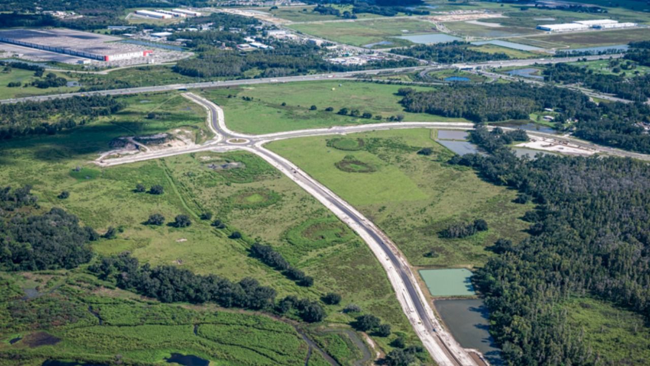 Aerial view of Kinfield development in Pasco County showing newly built roads, a roundabout and undeveloped land.