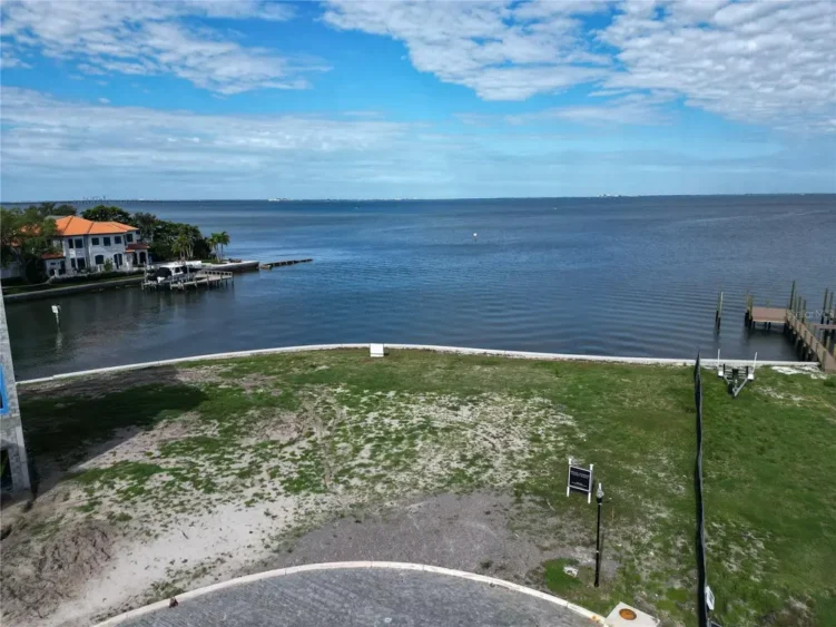 Aerial photos of Ndamukong Suh's former South Tampa waterfront lot in Madsen Isles, showing the vacant property, seawall, surrounding luxury homes and Tampa Bay.