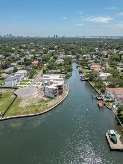 Aerial photos of Ndamukong Suh's former South Tampa waterfront lot in Madsen Isles, showing the vacant property, seawall, surrounding luxury homes and Tampa Bay.