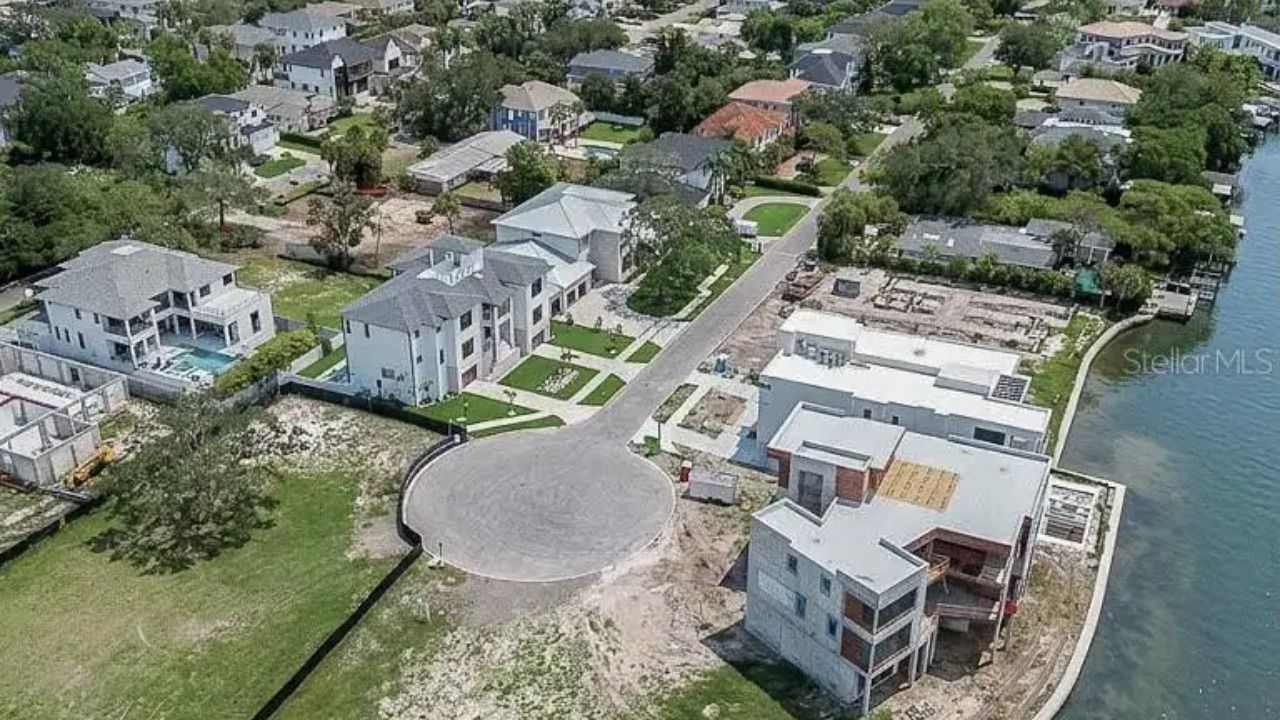 Aerial view of a vacant waterfront lot at the end of a cul-de-sac in South Tampa's Madsen Isles neighborhood, surrounded by luxury homes.