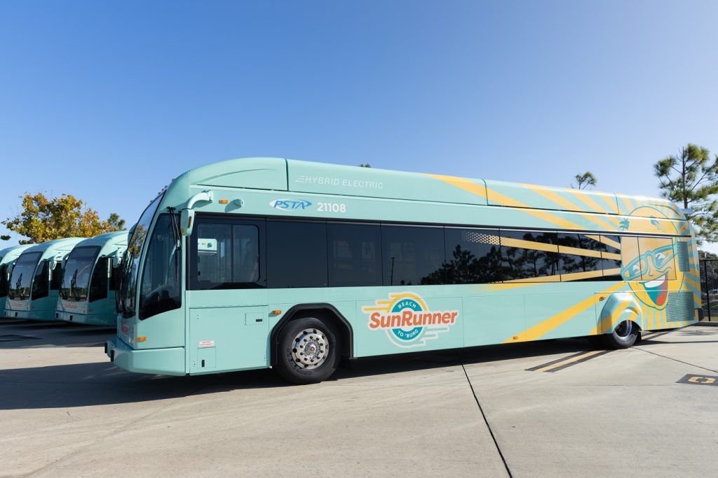 Turquoise PSTA SunRunner hybrid-electric bus parked alongside other buses in St. Petersburg